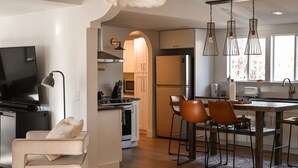 Une cuisine moderne avec un coin repas, un téléviseur et un espace salon confortable.