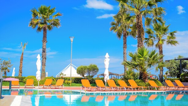 A pool area with lounge chairs and palm trees. - FAFA Mel Holiday Hotel (Golem)