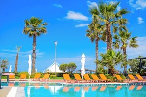 Una piscina al aire libre de temporada, sombrillas