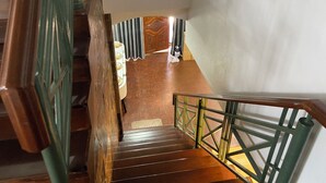 A wooden staircase with metal railings leading to a room with a patterned wall and a window with curtains. - Private Villa 5 min from Patong Beach,Center Patong,Jungceylon. Bangla Road Gate (Pa Tong)