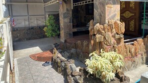 A stone-walled entrance with a small tree and a rock formation. - Private Villa 5 min from Patong Beach,Center Patong,Jungceylon. Bangla Road Gate (Pa Tong)