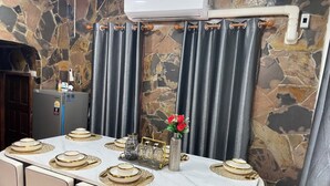 A dining table set with gold-rimmed plates and a vase with red flowers. - Private Villa 5 min from Patong Beach,Center Patong,Jungceylon. Bangla Road Gate (Pa Tong)