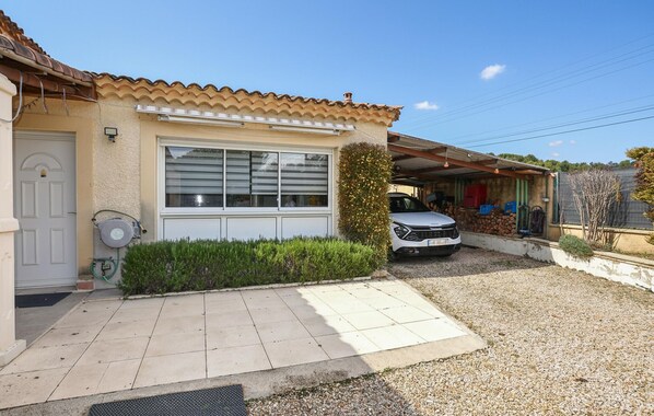 Una casa residencial con techo de tejas, garaje y entrada para vehículos.