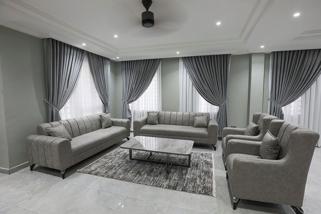 Un salon moderne avec un canapé gris, une table basse et un tapis.