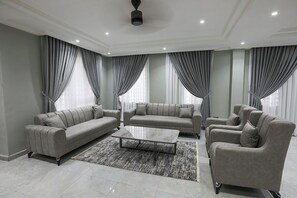 A modern living room with a grey sofa set, a coffee table, and a rug.
