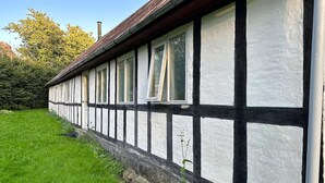 Un bâtiment traditionnel à colombages, doté d’un toit en pente et de nombreuses fenêtres.