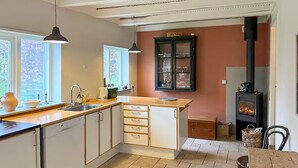 Une cuisine dotée d’un îlot central, d’une cuisinière et d’un meuble avec des portes en verre.