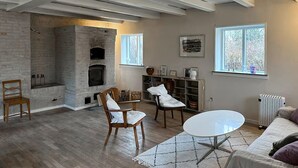 Un salon avec une cheminée, des meubles en bois, une table ronde blanche et un radiateur.