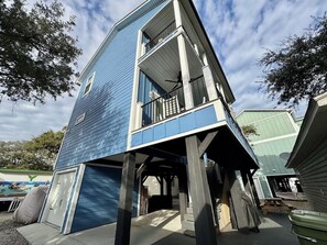 A two-story building with a blue exterior, a balcony on the upper floor, and a covered outdoor area.