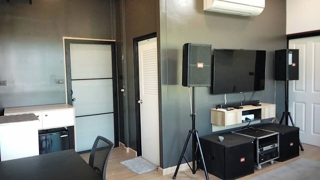 Ein kompakter Wohnbereich mit Küchenzeile, Essplatz, Wand-Fernseher und einer kleinen Sitzecke.