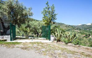 A gated entrance with a clear view of a hilly landscape in the background.