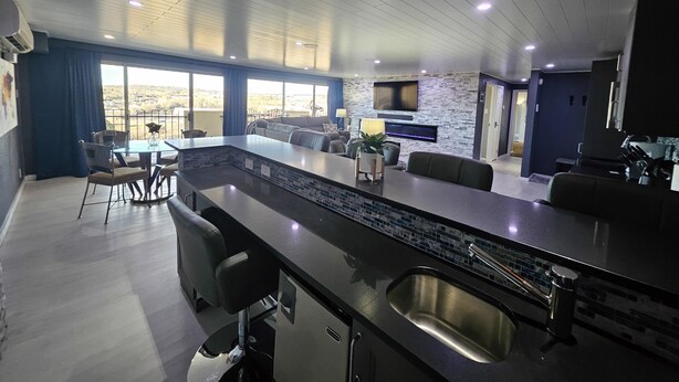 A modern kitchen with a large island, built-in appliances, and a dining area with a view.