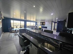 A modern kitchen with a large island, built-in appliances, and a dining area with a view. - Open and Spacious Condo with Exquisite Views! (Colorado Springs)