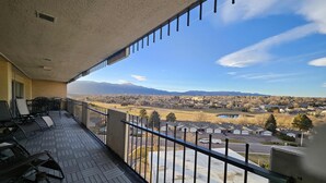A balcony with a view of a residential area, including houses and a lake.
