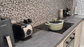 Una cocina moderna con un salpicadero de diseño hexagonal, estufa integrada, tostadora y cafetera.