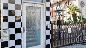 Proprietà privata con recinzione a scacchi, un portone con il numero 3212 e un cartello che indica parcheggio per biciclette e scooter durante il servizio al tavolo.