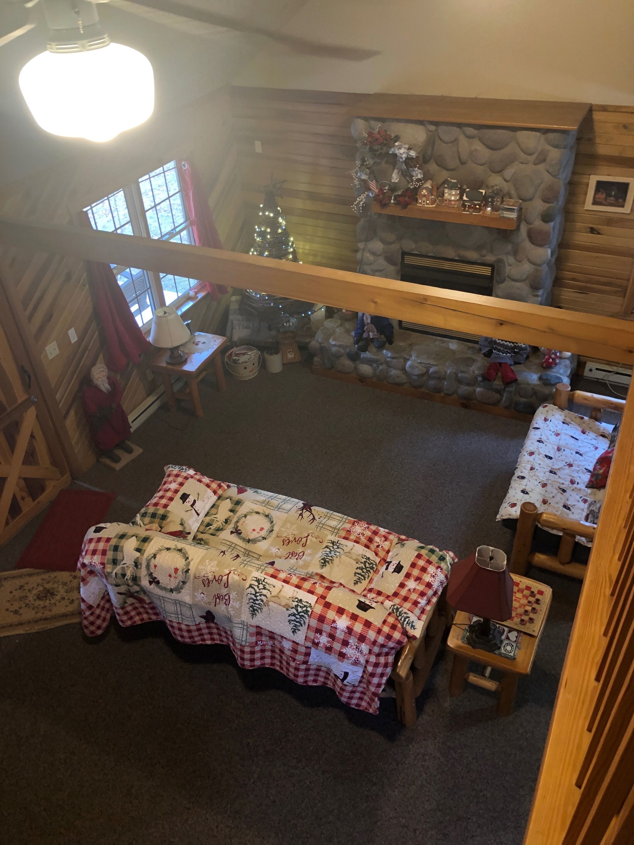 Une pièce chaleureuse avec une nappe à carreaux, une cheminée en pierre et un sapin de Noël.