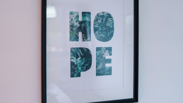 A framed artwork with the word "HOPE" in large letters, each letter filled with a nature-themed design. - Leeds Urban Escape / Bright & Spacious 3BR Stay (Leeds)