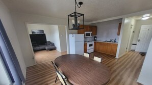 Une cuisine moderne avec des meubles en bois, un réfrigérateur blanc, un four à micro-ondes et une cuisinière.