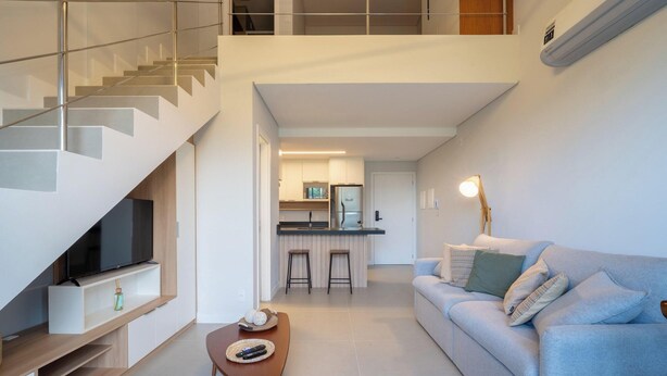 Een modern appartement met woonkamer, keuken en wenteltrap.