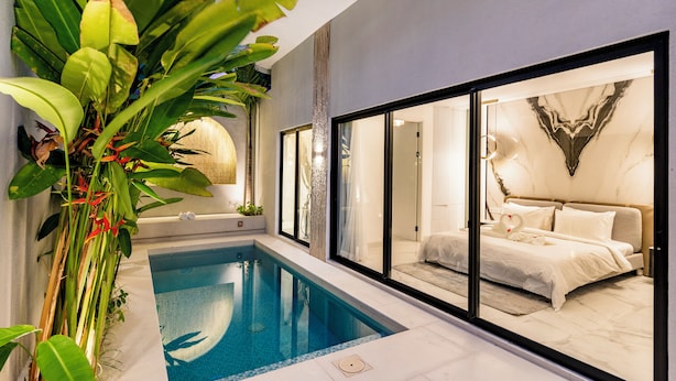 A modern hotel room with a large bed, a private bathroom, and a small indoor pool. - Anoya Boutique Villa (Kerobokan)