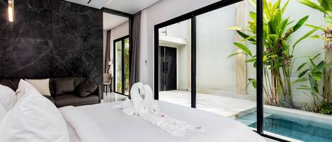 Una habitación de hotel moderna con una cama grande, una pared de mármol oscuro y vistas a una piscina.