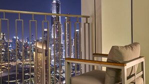 A balcony with a cityscape view, a chair, and a railing. - Spacious 4-Bedroom Downtown Apartment with Burj Views (Dubai)