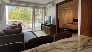Een moderne woonkamer met een marmeren tafel, een bank en een televisie.