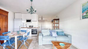 A compact living space with a dining area, kitchenette, and a sofa. - Studio Merle - Welkeys (Bandol)
