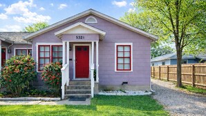 A single-story house with a red door, numbered 5321, and a front porch.