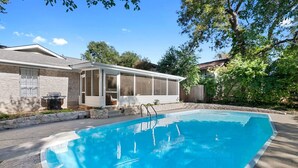 Una piscina con una casa sullo sfondo.