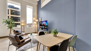 A modern meeting room with a large flat-screen TV, comfortable seating, and a city view. - Downtown Dallas Gem - 1000Mbps Fiber, Free Valet & Pool (Dallas)
