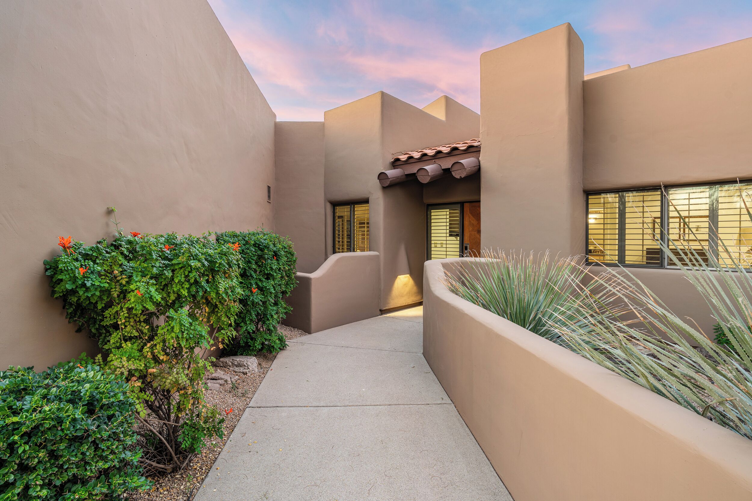 Private front entry with Southwest architecture and desert landscaping for a warm welcome.