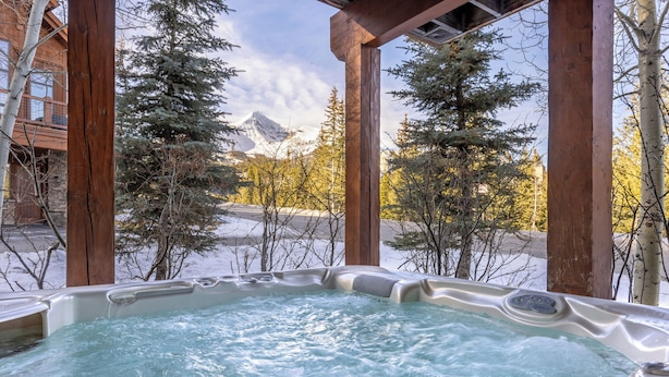 A hot tub with a view of snow-covered mountains and trees. - Ski In/Out | Black Eagle Base-Inn | Big Sky Resort (Big Sky)