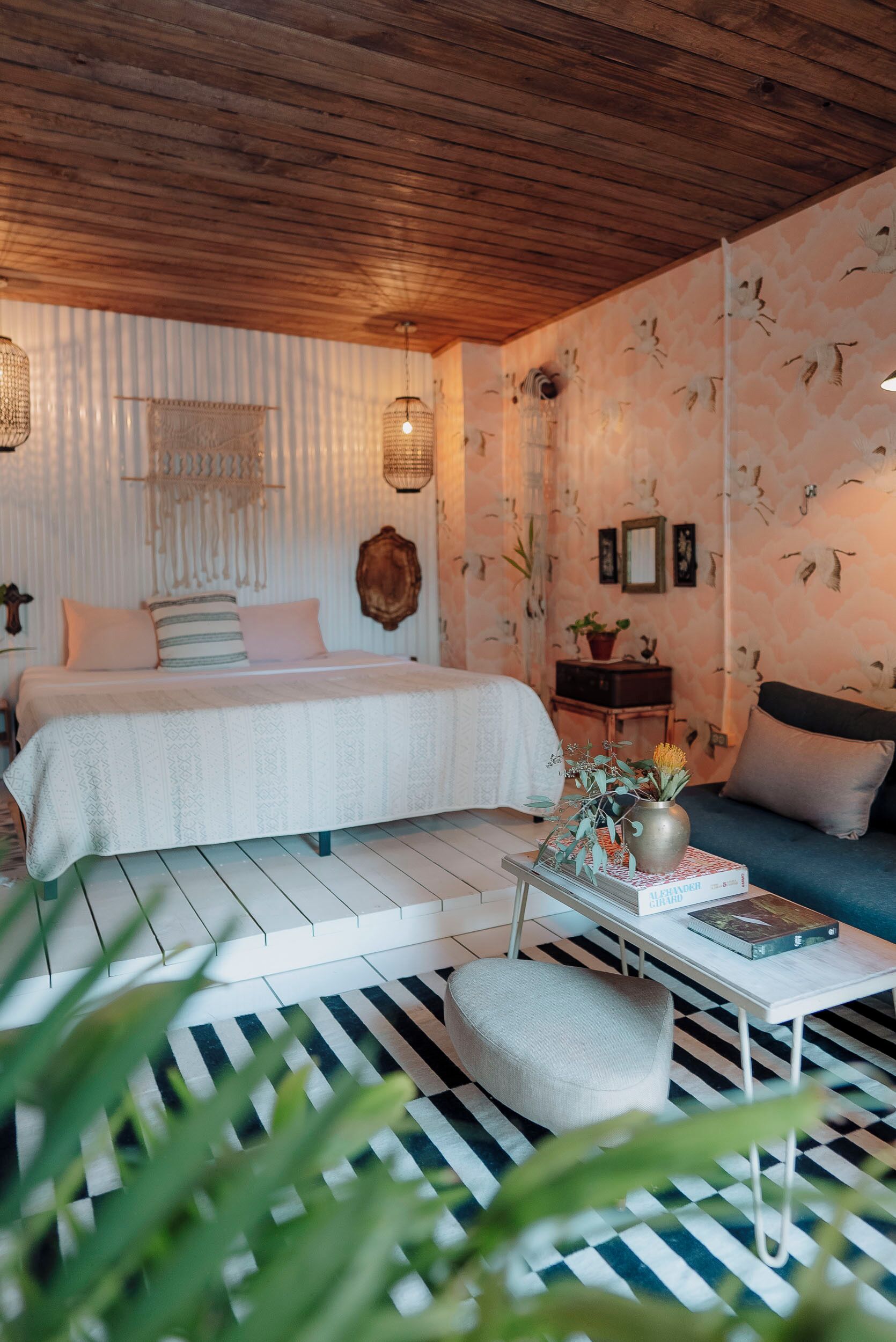 A bedroom with a bed, bedside table, and a sofa.