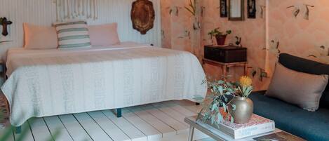 A bedroom with a bed, bedside table, and a sofa.