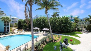 A swimming pool with lounge chairs, palm trees, and a well-maintained lawn. - Sanibel Island condo - Close to the beach - Colony Inn 01 (Sanibel)