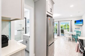 Een moderne keuken met een koelkast, een spoelbak en een douche met glazen wanden.