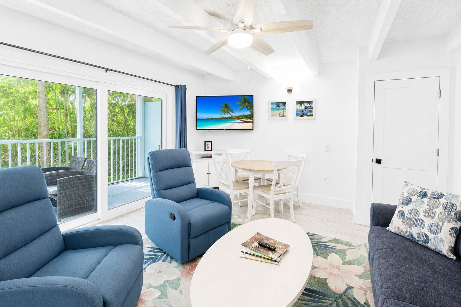 A living room with a ceiling fan, a TV, a dining table with chairs, and a sofa.