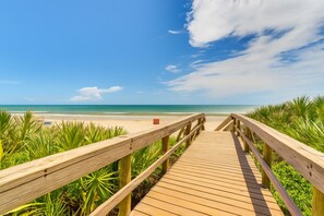 A wooden boardwalk leading to a beach with clear skies and calm waters. - Spacious 3BR/2BA Resort Condo with Pools and Private Beach Access – New Smyrna (New Smyrna Beach)