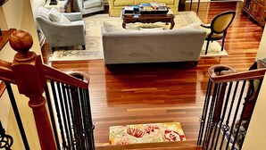 Un amplio salón con una escalera que conduce al piso superior.