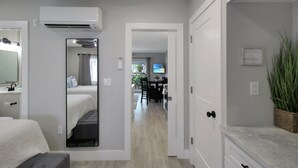 Ein modernes Hotelzimmer mit Bett, Nachttisch, Spiegel, Klimaanlage und Blick auf den Speisesaal.
