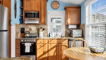 Full kitchen with gas range, microwave, marble counters, and dinette seating.