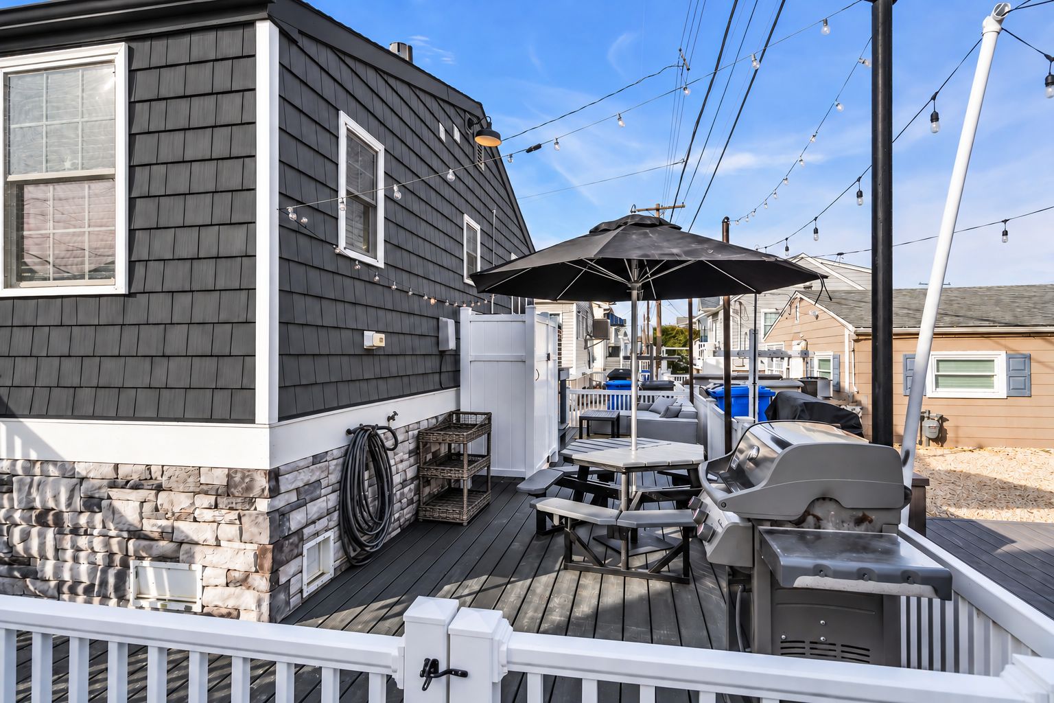 Private outdoor deck with bistro dining table, umbrella, and seating for four.