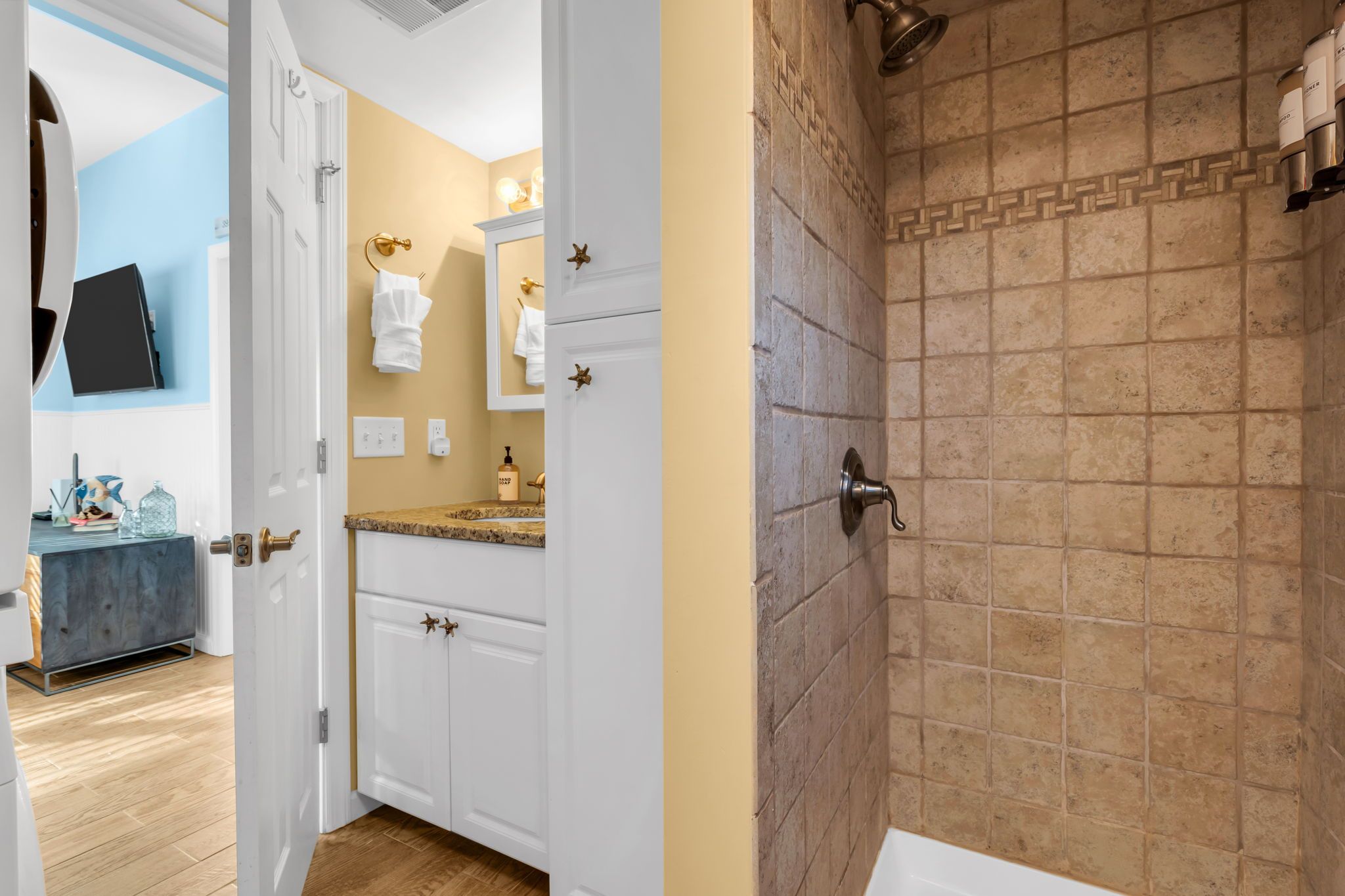 A bathroom with a shower, a sink, and a vanity with a mirror.