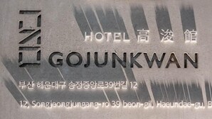 Une enseigne d’hôtel portant le nom « Gojunkwan » et son adresse en coréen et en anglais.