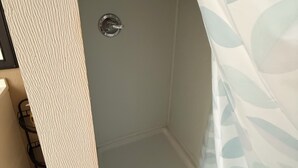 Ducha con puerta blanca y desagüe.