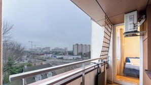 En balkong med utsikt över en stadsbild, inklusive byggnader och en byggkran.