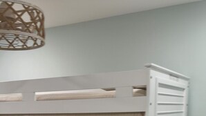 A bunk bed with a beige bedspread, white headboard, and a woven light fixture above. - 2-Bedroom Beachfront Condo on Private Beach Longboat Key (Longboat Key)