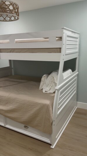 A bunk bed with a beige bedspread, white headboard, and a woven light fixture above. - 2-Bedroom Beachfront Condo on Private Beach Longboat Key (Longboat Key)